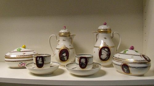 A late 18th/early 19th century Vienna porcelain part coffee service, each painted with grisaille pro
