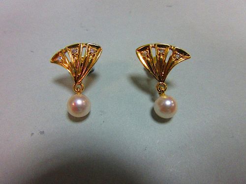 A pair of pearl and diamond earstuds, each with a pierced triangular fan motif set with three round