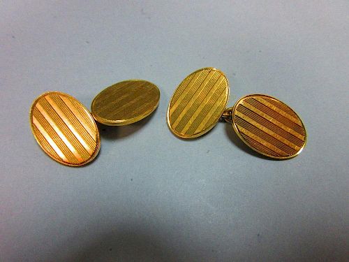 A pair of 18ct gold double-ended cufflinks, each oval end with incised striped decoration, chain con