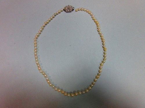 A pearl necklace with art deco diamond clasp, the individually knotted string of graduated 3.8-5.2mm
