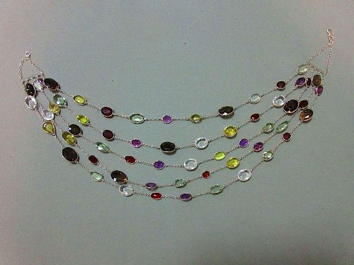 A five strand multi gemset necklace, composed of oval cut hessonite garnets, prasiolites, amethysts,
