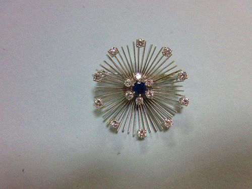 A mid 20th century diamond and sapphire flower brooch, formed by a central round cut sapphire in a s