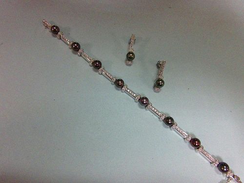 A black pearl and diamond bracelet and earring suite set in 18ct white gold, the bracelet designed a