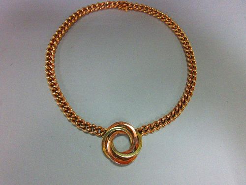 A curb link chain necklace with central knot feature, the knot composed of three square section inte