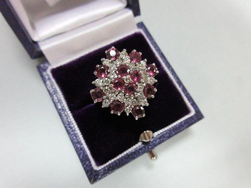 A ruby and diamond cluster ring in 18ct white gold, designed as a densely set diaper with a quatrefo