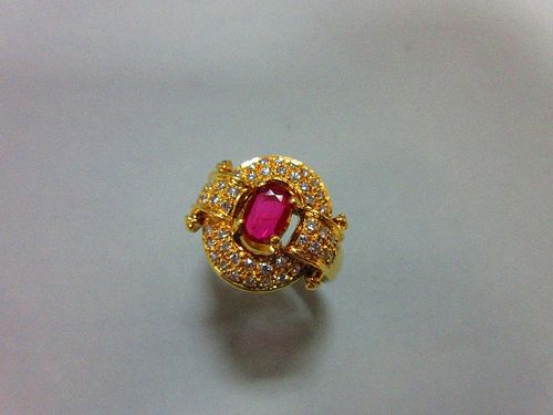 A red hardstone and diamond cluster ring, the oval cut red stone, believed to be a ruby, but not lab