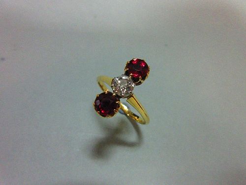 A ruby and diamond three stone ring, the vertically set stones being an old round brilliant cut diam