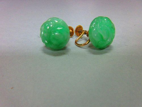 A pair of carved jadeite jade screwback earrings, each bouton of light emerald green mottled jade ca