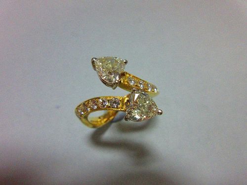 A heart-cut diamond crossover ring, with two well-matched heart-shaped brilliant diamonds forming th