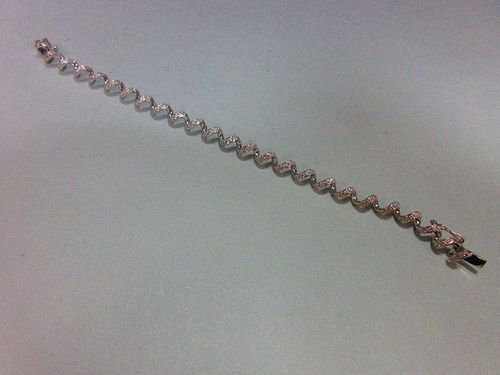 A spiral link diamond bracelet, the continuous smooth line of links forming an open centre corkscrew