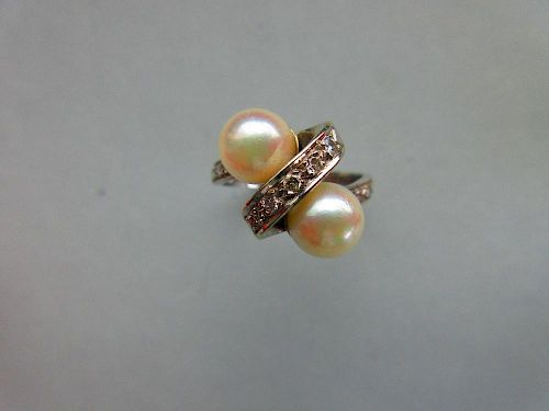 A Continental white gold, pearl and diamond crossover ring, the plain shank set to the front with ro