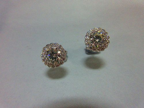 A pair of diamond cluster earstuds, each designed as a four claw set principal round brilliant cut d