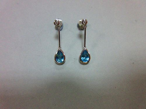 A pair of blue topaz, diamond and white gold earpendants, each post headed by a collet set round bri