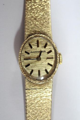 By Longines - a lady's 9ct gold cased wristwatch, the oval gold coloured dial with baton numerals, i