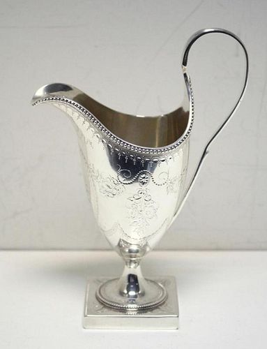 A George III silver creamer, by Hester Bateman, London 1786, of helmet shape, the body engraved with