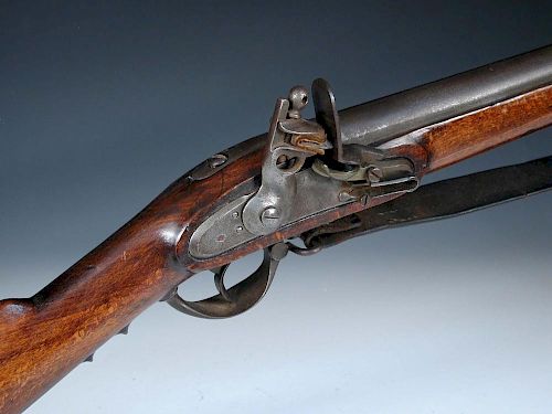 An early 19th century 'Brown Bess' type flintlock musket, the steel barrel with bayonet socket and b