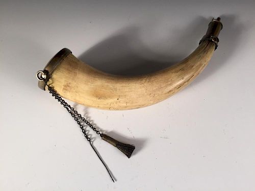 A late 18th or early 19th century powder horn, brass mounted, one end engraved with the crest of the