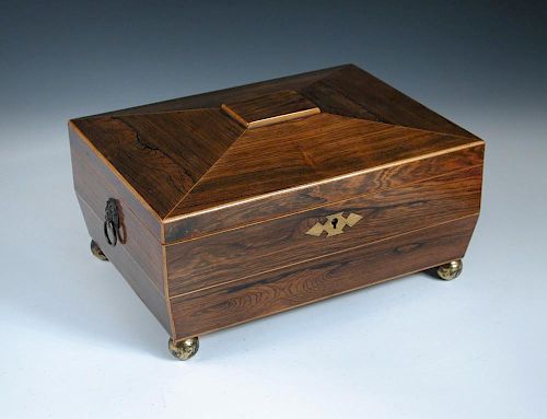 An early 19th century rosewood workbox converted to a humidor, of sarcophagus form, on four gilt bra