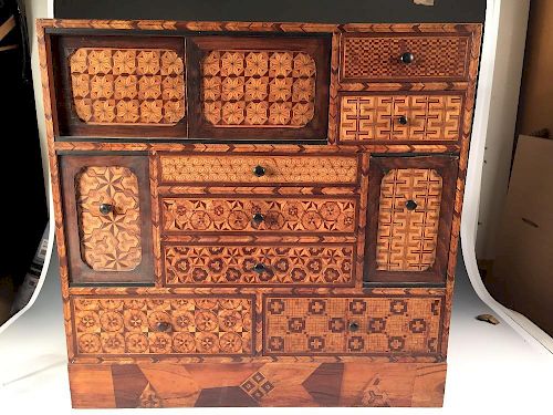 An early 20th century specimen wood parquetry cabinet, the rectangular front with a configuration of