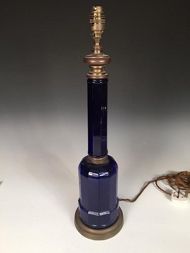 A Victorian blue glass table lamp, the octagonal column above a broad base and brass mounts, convert