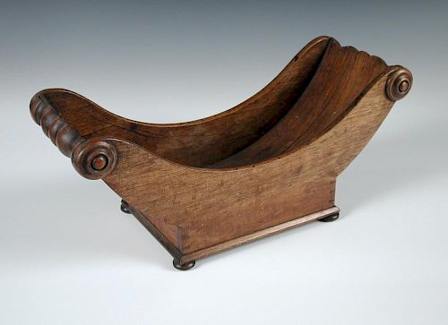 A 19th century mahogany cheese coaster, the curve shaped body raised on four bun feet 19 x 44cm (7 x