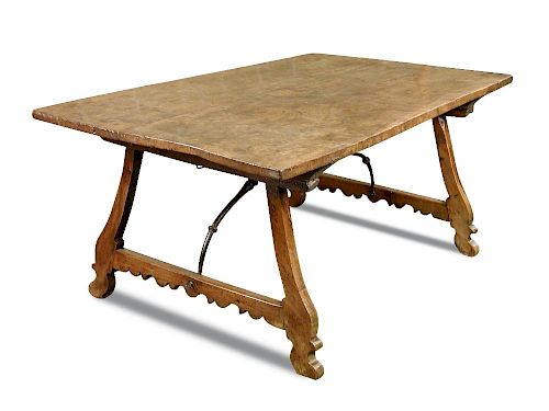 A 17th century Spanish walnut refectory table, the heavy plank top on silhouette carved legs united