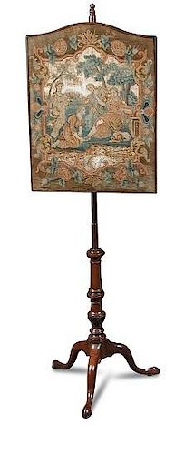 A George III mahogany pole screen, with arched needlepoint panel, on a turned moulded column and a t