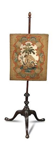 A George III mahogany pole screen, petit point panel depicting a game keeper, the tripod base carved