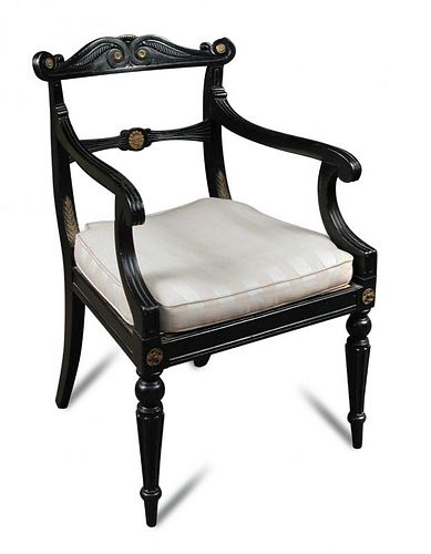 A Regency ebonised and gilt mounted elbow chair, with cane seat and squab, carved back, on gadroon m