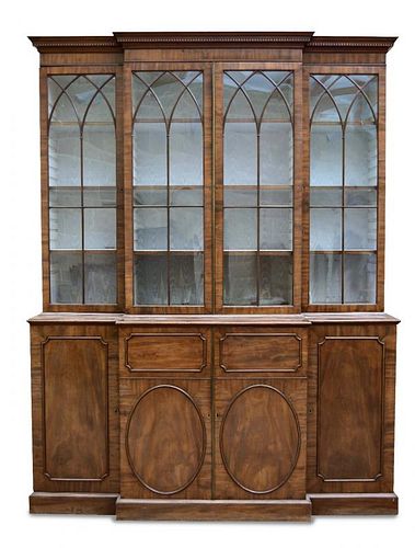 A George III mahogany breakfront library bookcase, with dentil moulded cornice, gothic arched glazed