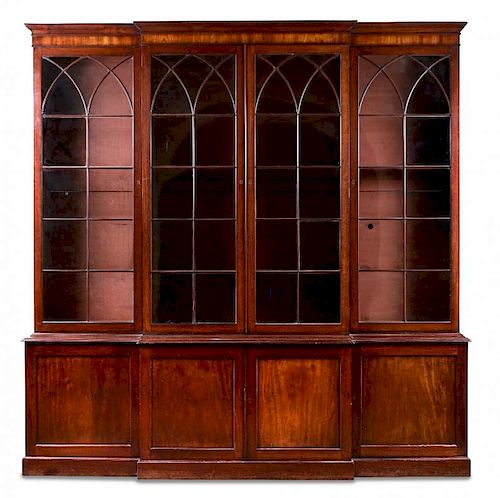 A George III mahogany breakfront library bookcase, with gothic arched glazed doors above and panelle