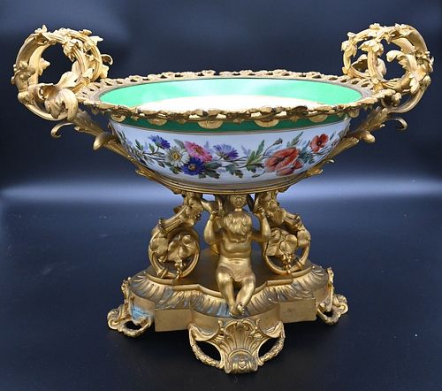 Large French Porcelain Center Bowl, having ormolu bronze scrolling handle on figural base, modeled as two putti figures holding up the bowl, height 14