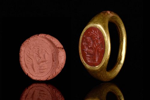 A ROMAN GOLD AND CARNELIAN RING WITH TWO RAMS UNDER A TREE