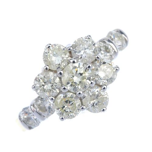 An 18ct gold diamond cluster ring. The brilliant-cut diamond floral cluster, to the similarly-cut di