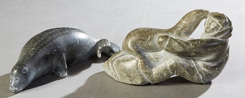 Two Carved Inuit Soapstone Figures, 20th c., one of a hunter with an ivory knife and a seal; the second of a large seal, H.- 3 in., W.- 9 7/8 in., D.-