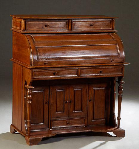 French Carved Mahogany Cylinder Desk, early 20th c., the stepped top over two frieze drawers and a cylinder top opening to a fitted interior with four