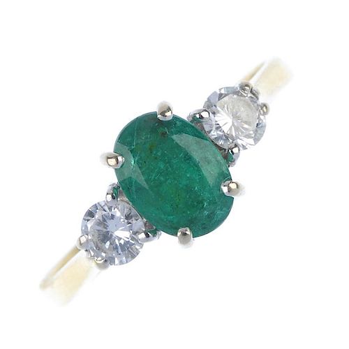 An 18ct gold emerald and diamond three-stone ring. The oval-shape emerald, with brilliant-cut diamon