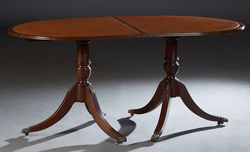 English Inlaid Mahogany Double Pedestal Dining Table, 20th c., the oval reeded edge top on turned urn form supports to tripodal brass mounted legs wit