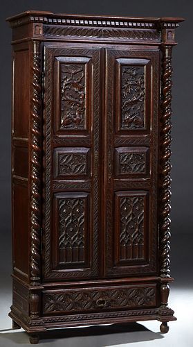 French Provincial Henri II Style Carved Oak Armoire, c. 1880, the dentillated breakfront crown over double doors with three carved panels each, flanke