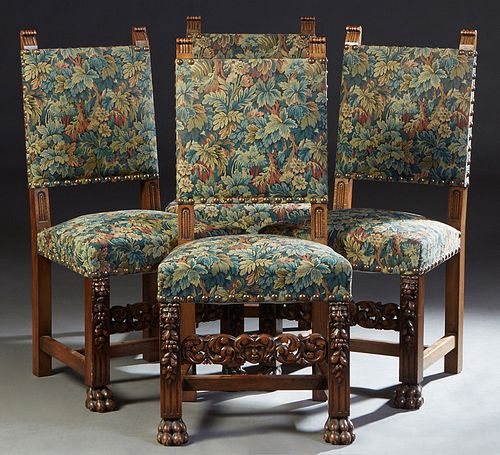 Set of Four French Provincial Carved Oak Dining Chairs, 20th c., the upholstered high back a over trapezoidal cushioned seat, on lions' head, fruit an