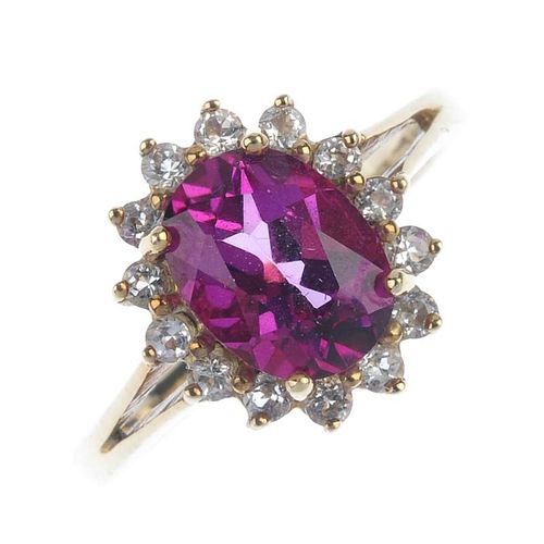 A 9ct gold coated topaz and diamond cluster ring.The oval-shape pink coated topaz and brilliant-cut