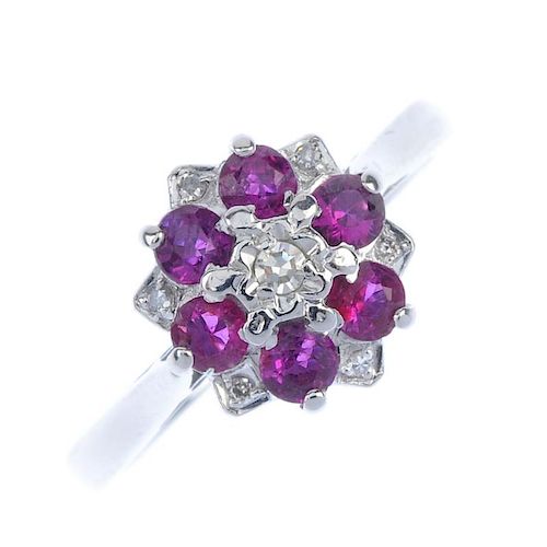 An 18ct gold ruby and diamond floral cluster ring. The single-cut diamond, within a circular-shape r