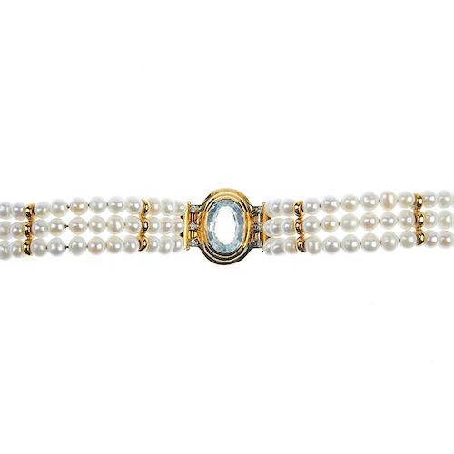 <p>A topaz, diamond and cultured pearl bracelet. The oval-shape blue topaz, within a grooved surroun