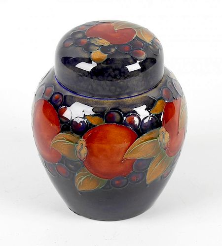 A William Moorcroft pottery Pomegranate and Berry pattern ginger jar Of ovoid form with domed cover