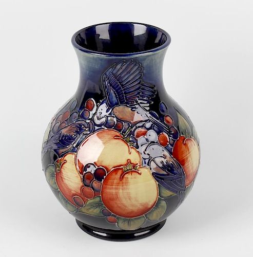 A Moorcroft pottery 'Finches' pattern vase. The bulbous body with tube-lined decoration on a blue gl