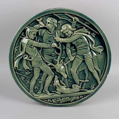 An Arts and Crafts pottery plaque. Of circular form, decorated with raised hunting scene of three fi