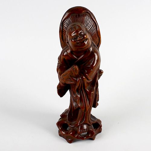 A 19th century Oriental carved rootwood figure. Modelled as an Immortal or similar, a wide-brimmed h