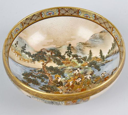 A Japanese Meiji period Satsuma pottery bowl. The interior decorated with figures on a promontory be