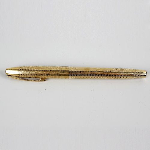 A 9ct gold Sheaffer fountain pen. Having 14k gold nib, the engine turned body with vacant rectangula