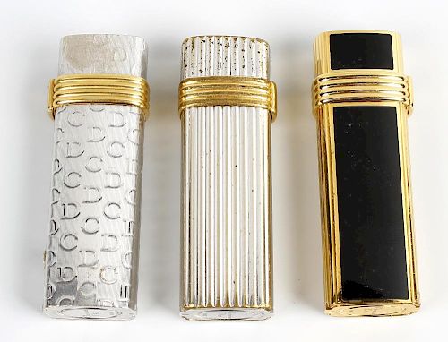 A selection of three Christian Dior lighters. Comprising two white gold plated examples stamped Plaq